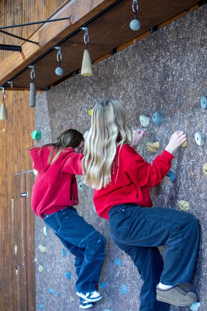 Oasis 2 girls red shirts rock climbing panned out shot