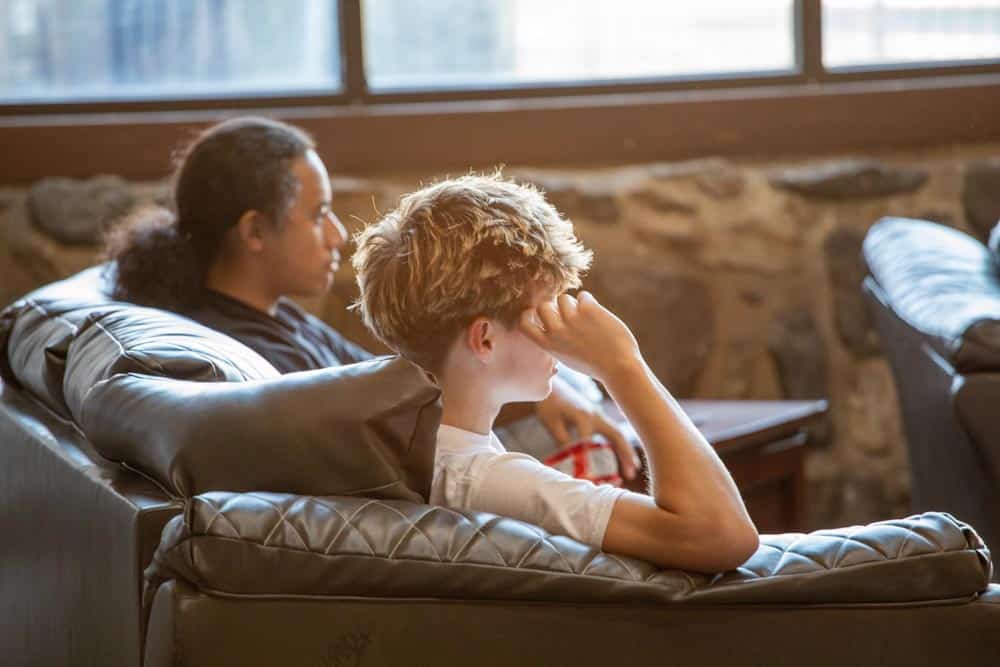 Oasis boys sitting on couches white shirt in front